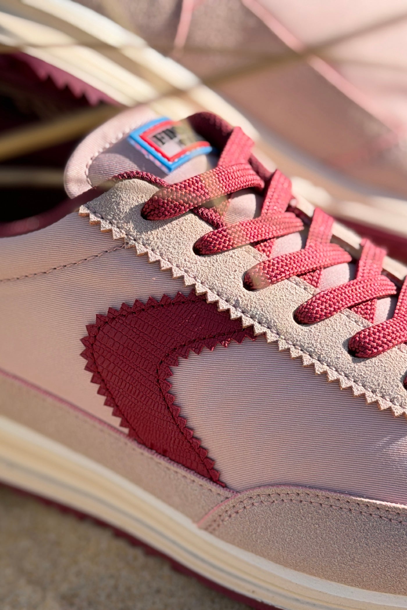Baskets style running rose poudré avec rayure, talon et semelle bordeaux