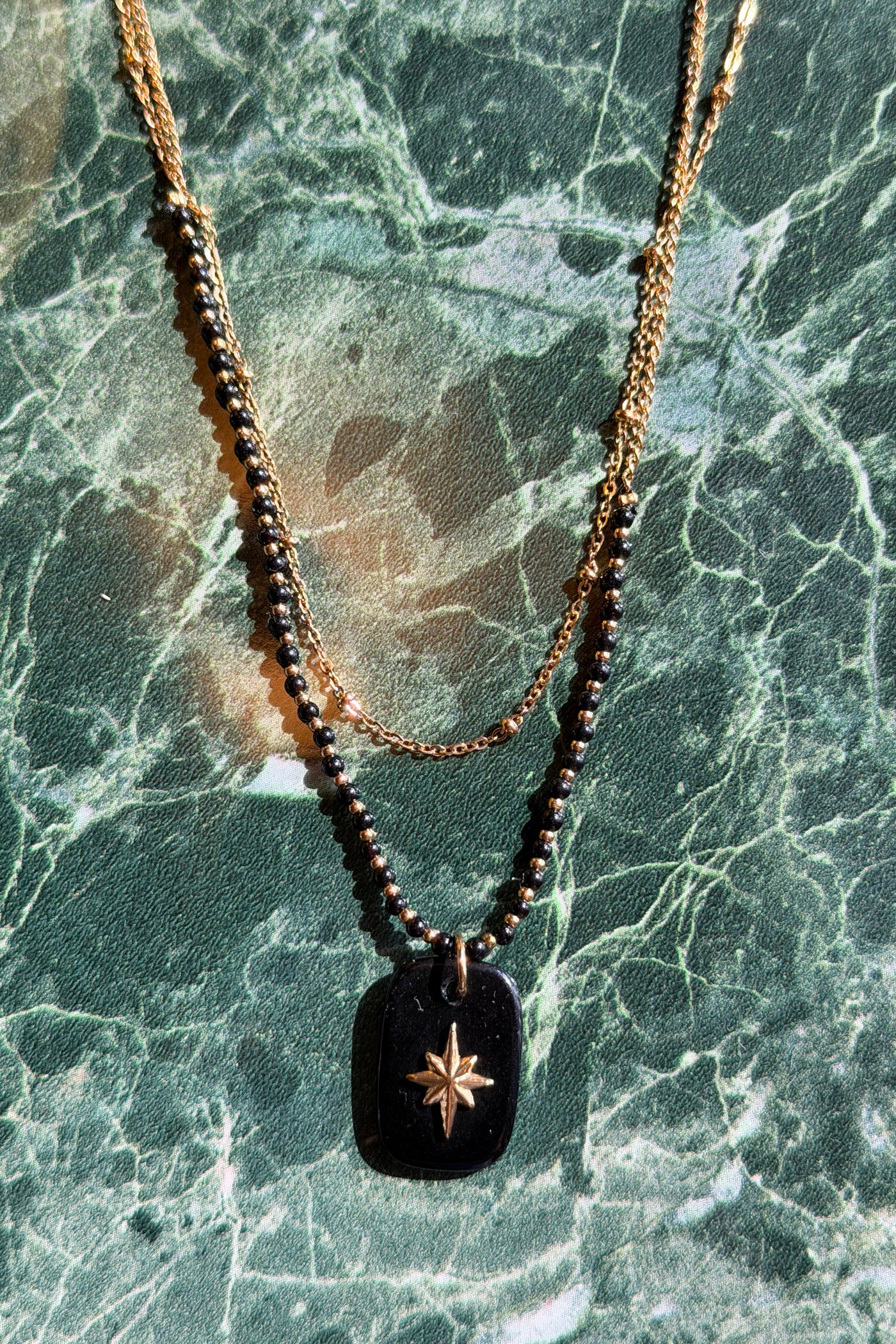 Collar de perlas doradas de dos hileras y colgante de estrella pequeña negra