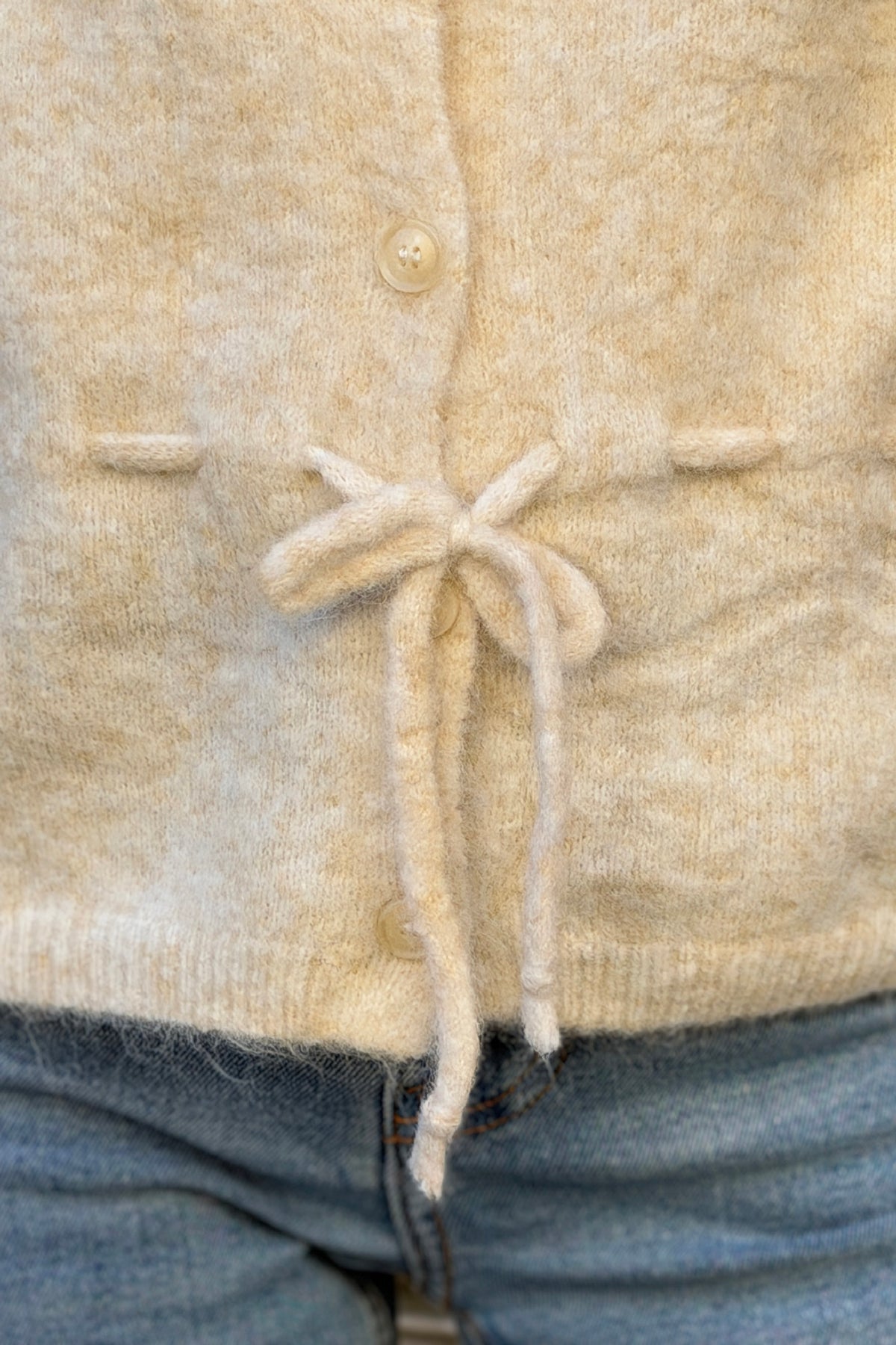 Gilet en maille beige chiné à boutons et lien à resserrer à la taille