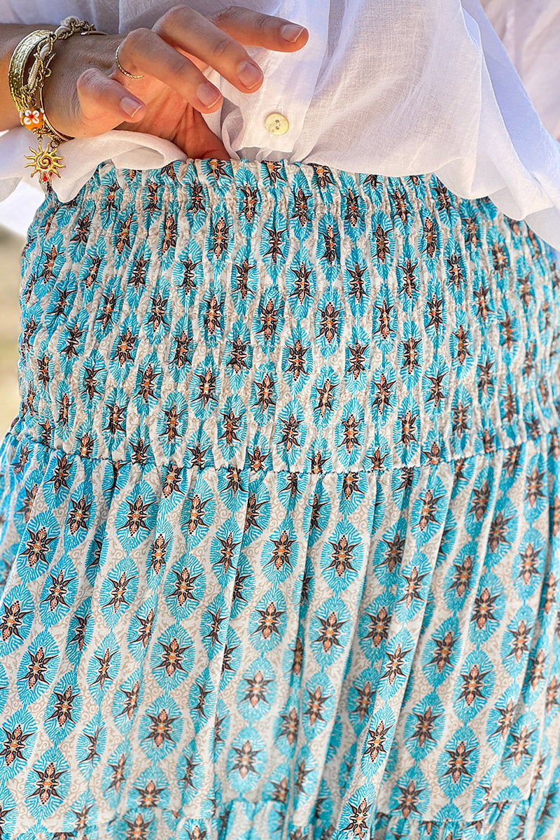 Falda larga y fluida de estilo bohemio con estampado de medallón étnico turquesa y cinturilla fruncida.