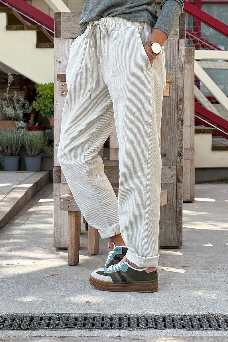 Pantalón de pana beige con pernera recta y cintura elástica con cordón ajustable.