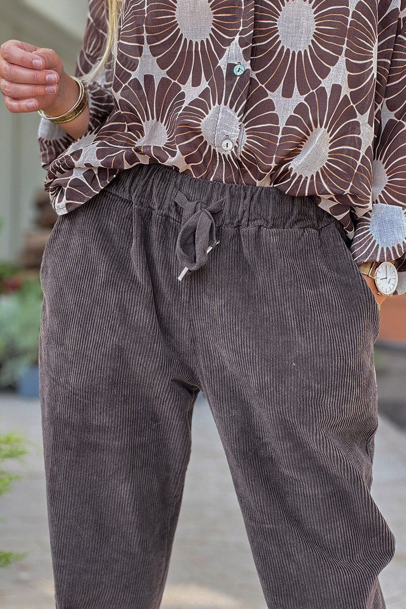 Pantalones de pana color marrón chocolate con pernera recta y cintura elástica con cordón ajustable.