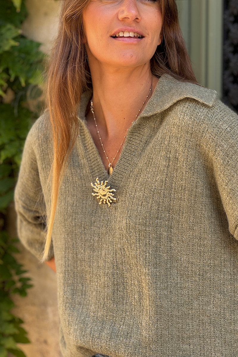 Suéter de punto color caqui jaspeado con mangas 3/4, cuello de camisa y broche dorado de sol.