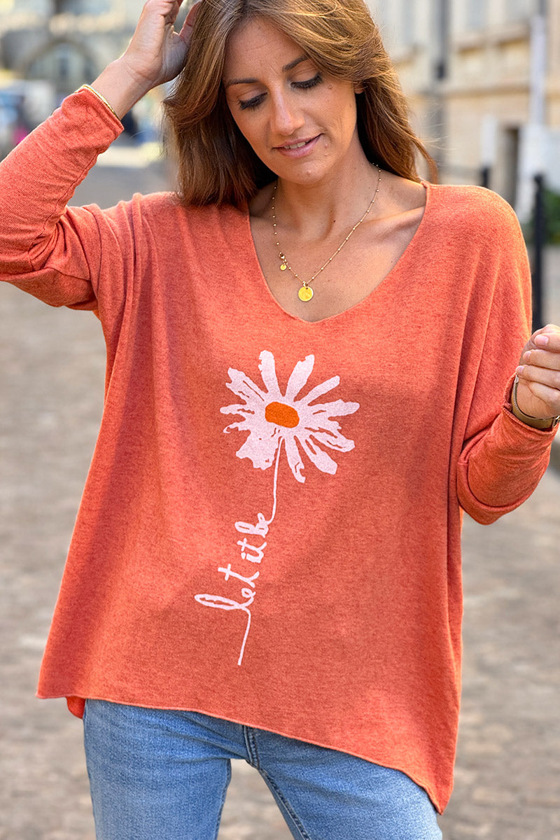 Suéter de punto suave color naranja con estampado de margaritas. Déjalo ser.