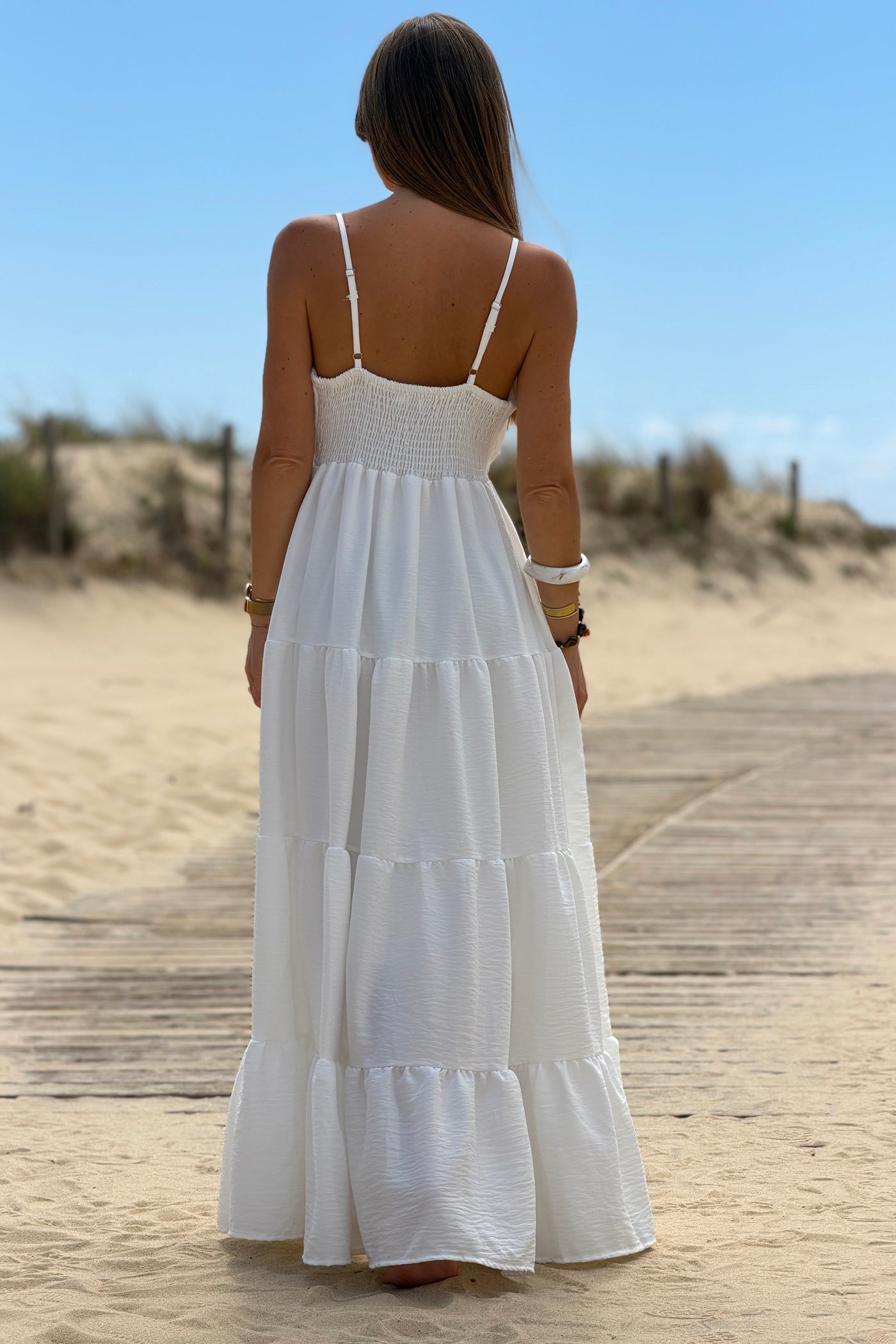 Robe longue à bretelles blanche détail broche soleil doré
