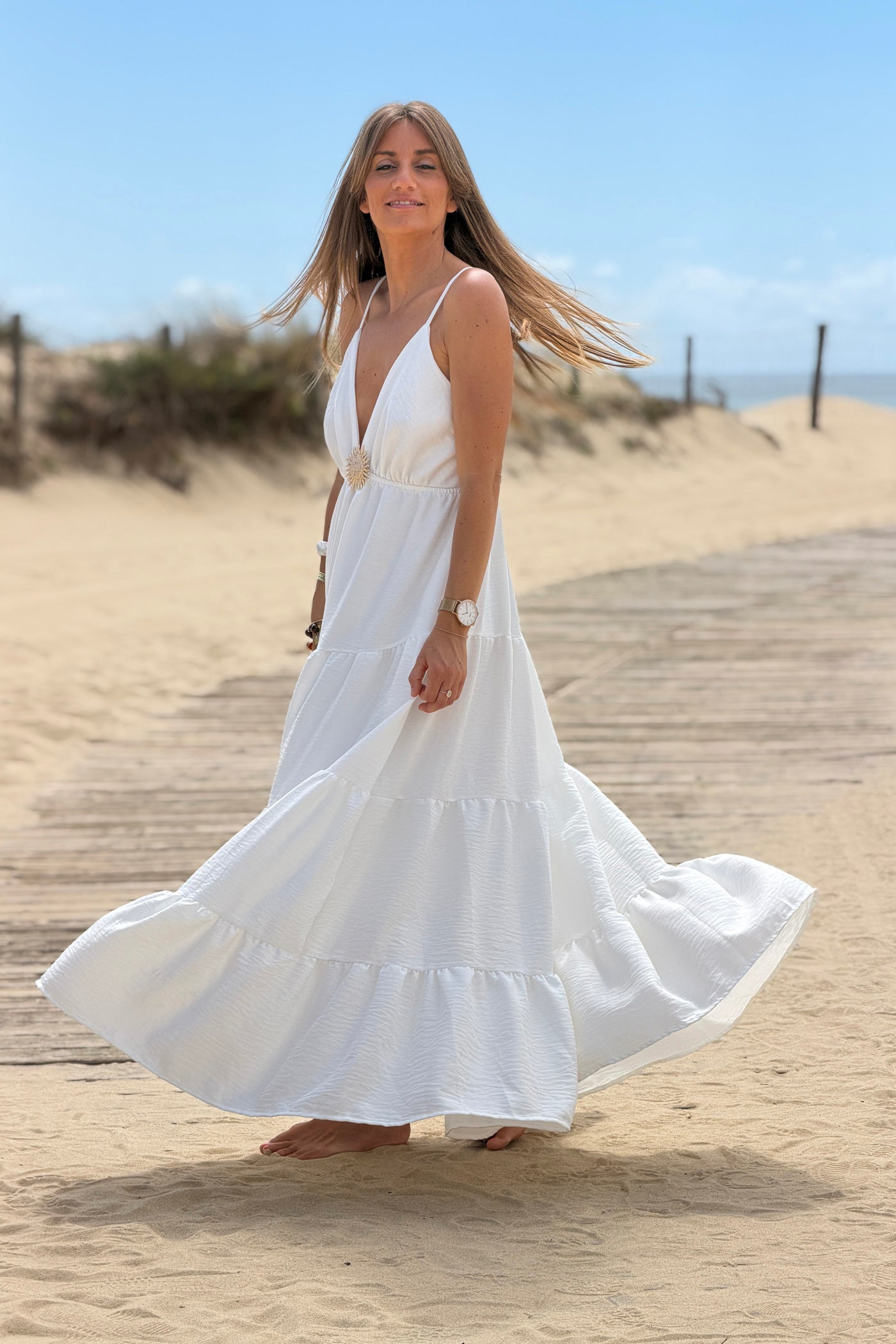 Robe longue à bretelles blanche détail broche soleil doré
