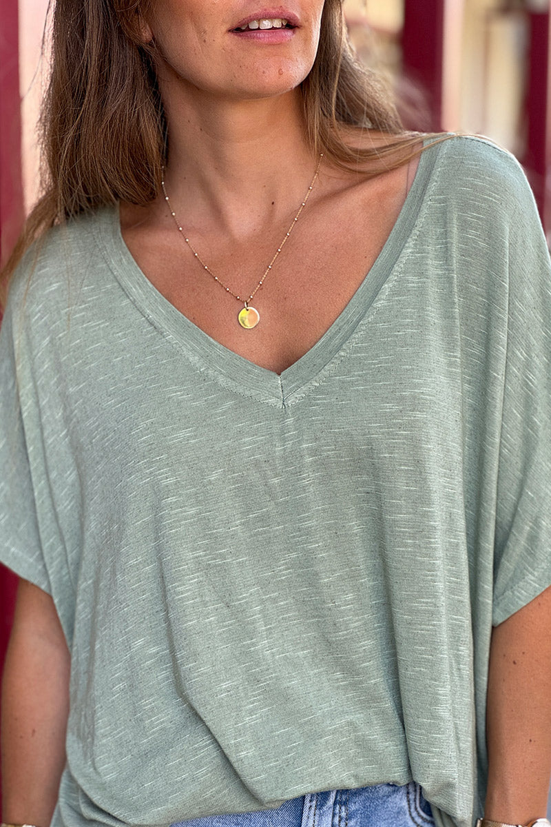 Camiseta holgada, elástica y de color caqui jaspeado, con cuello en V y mangas tipo murciélago.