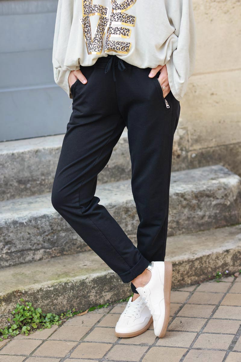 Pantalón jogging negro con ribete de cinta en los bolsillos laterales con cremallera cinturilla elástica