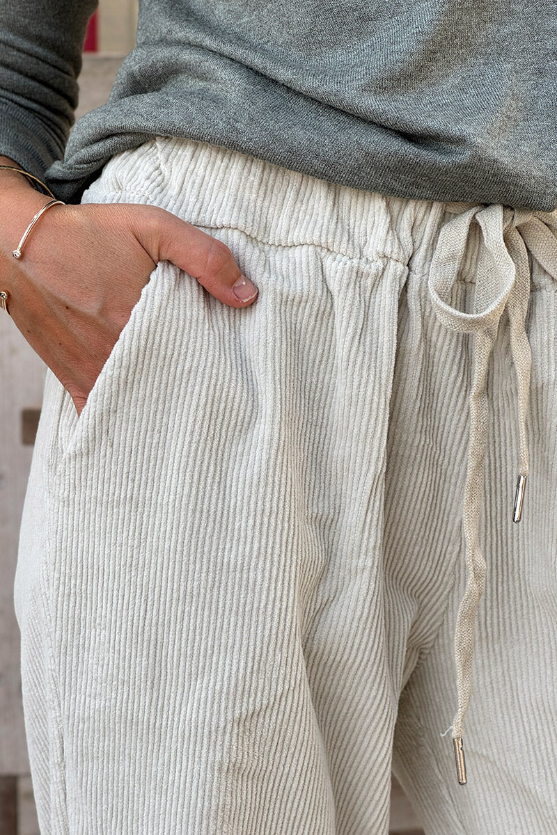 Pantalón de pana beige con pernera recta y cintura elástica con cordón ajustable.