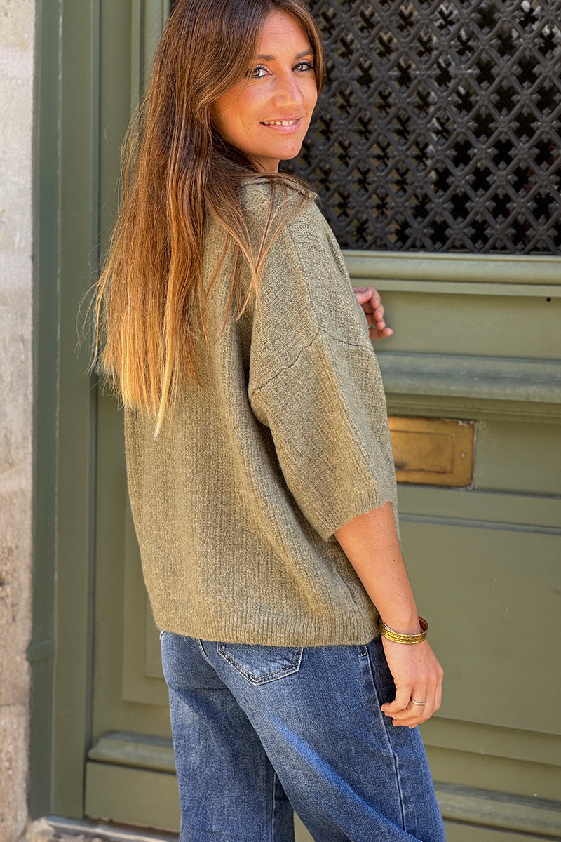 Suéter de punto color caqui jaspeado con mangas 3/4, cuello de camisa y broche dorado de sol.