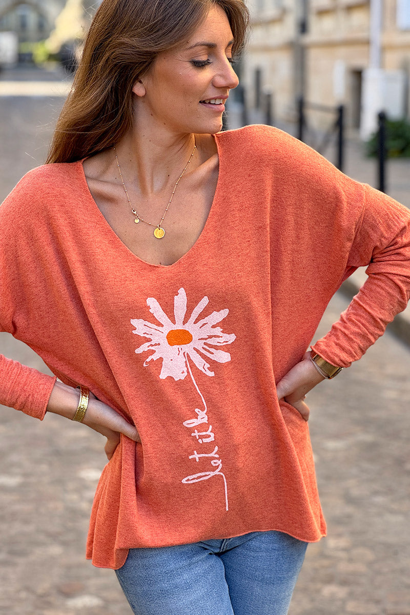 Suéter de punto suave color naranja con estampado de margaritas. Déjalo ser.