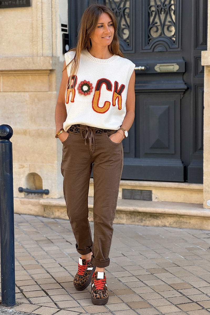 Suéter de punto sin mangas de color beige suave con bordado ROCK en tonos otoñales.