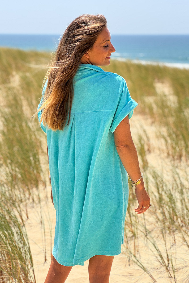 Vestido de rizo turquesa con cuello camisero y botones.