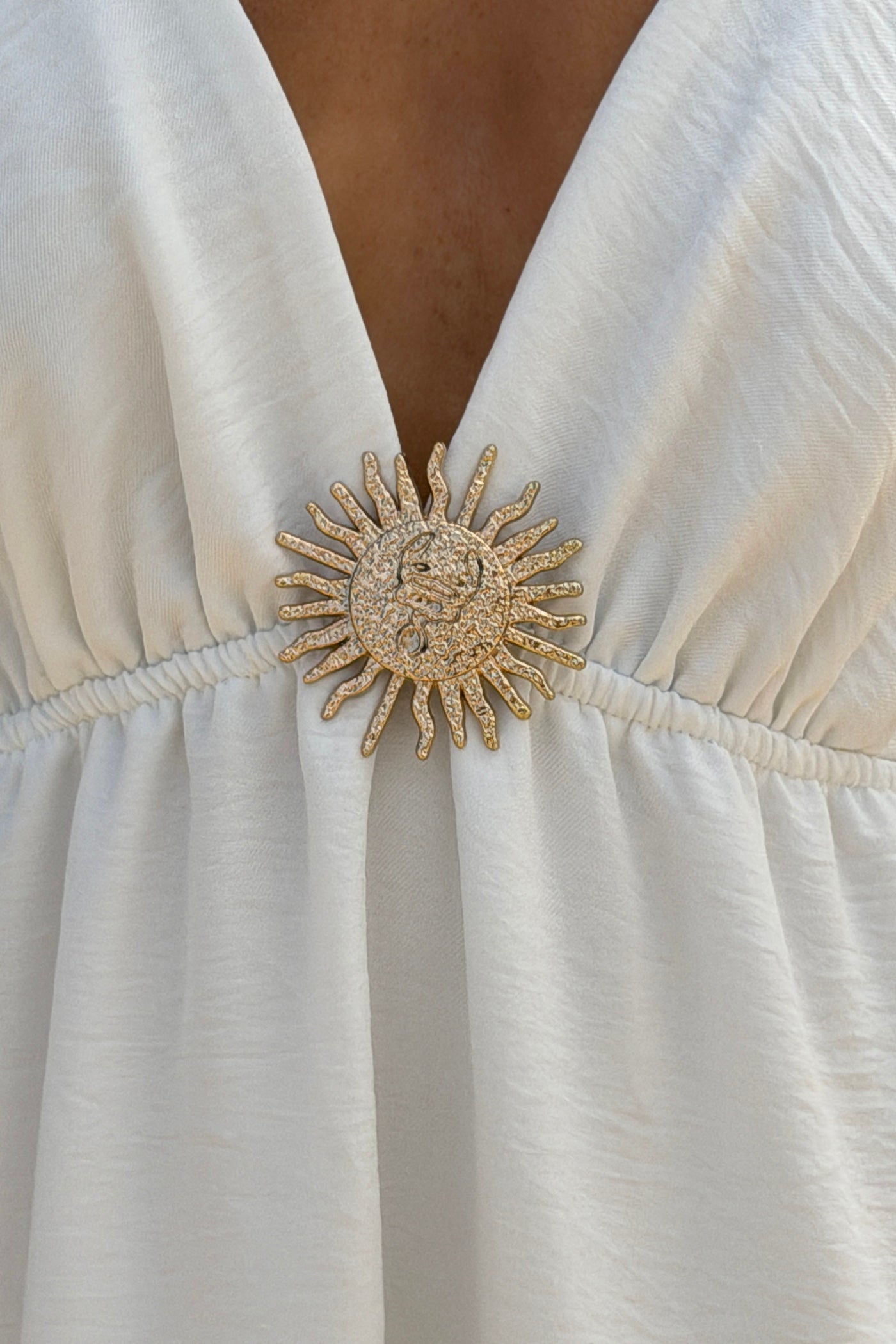 Robe longue à bretelles blanche détail broche soleil doré
