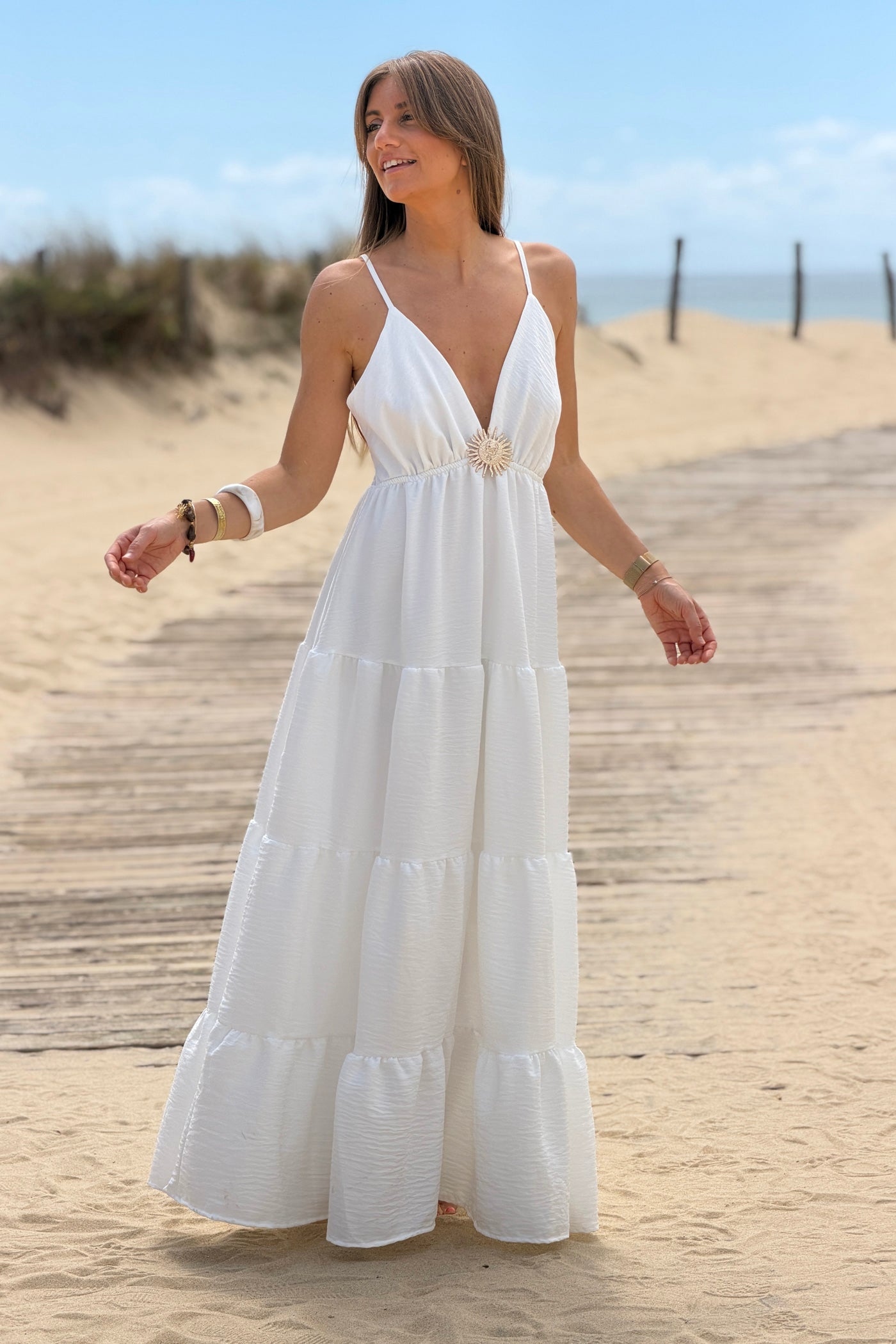 Robe longue à bretelles blanche détail broche soleil doré