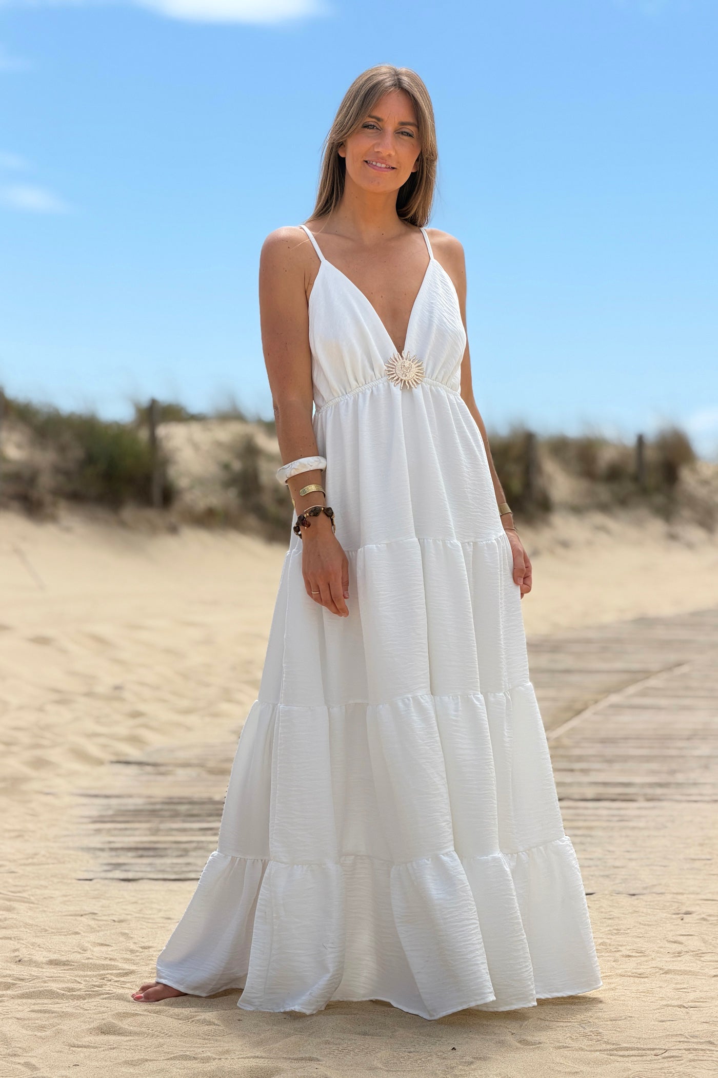 Robe longue à bretelles blanche détail broche soleil doré