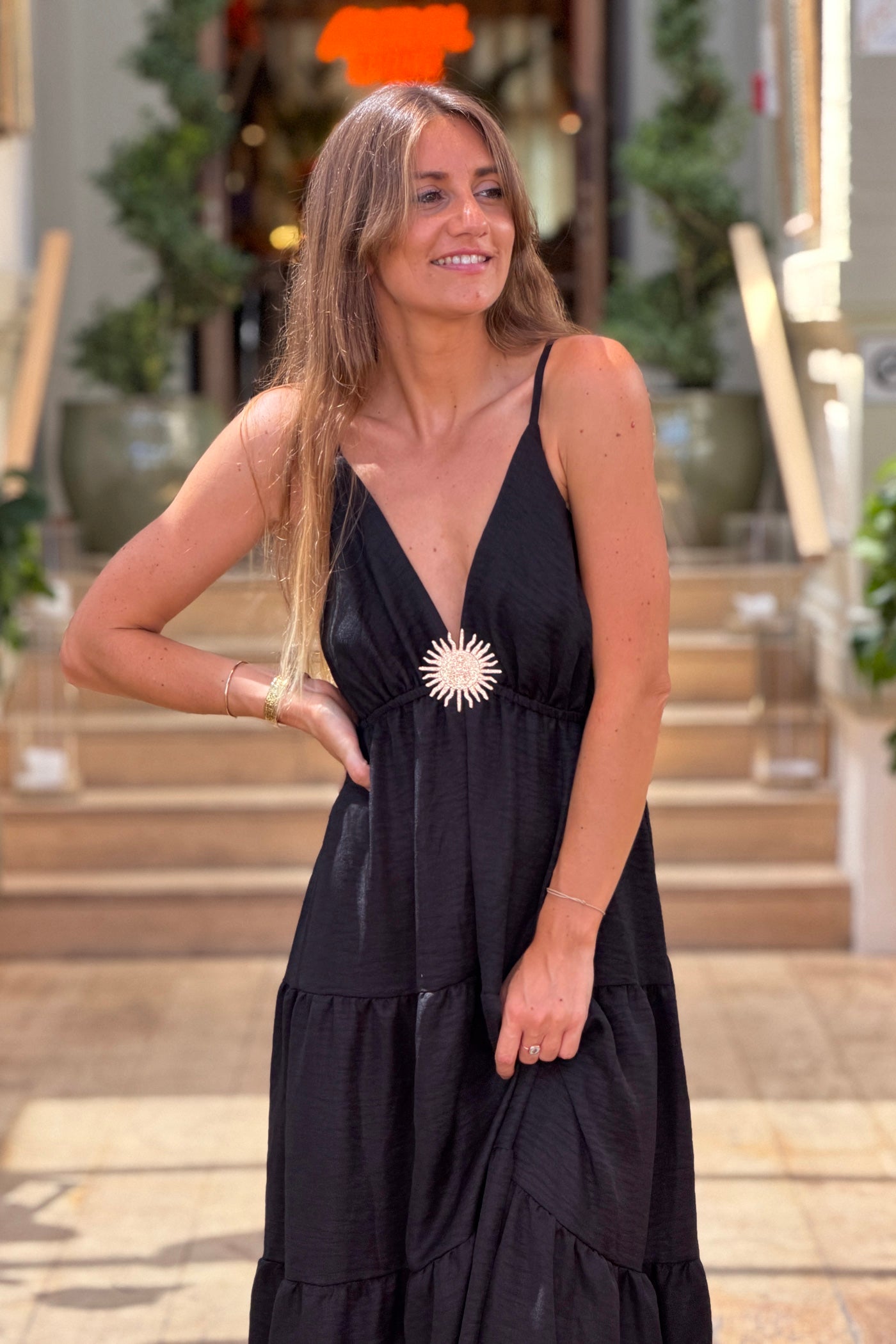 Robe longue à bretelles noire détail broche soleil doré