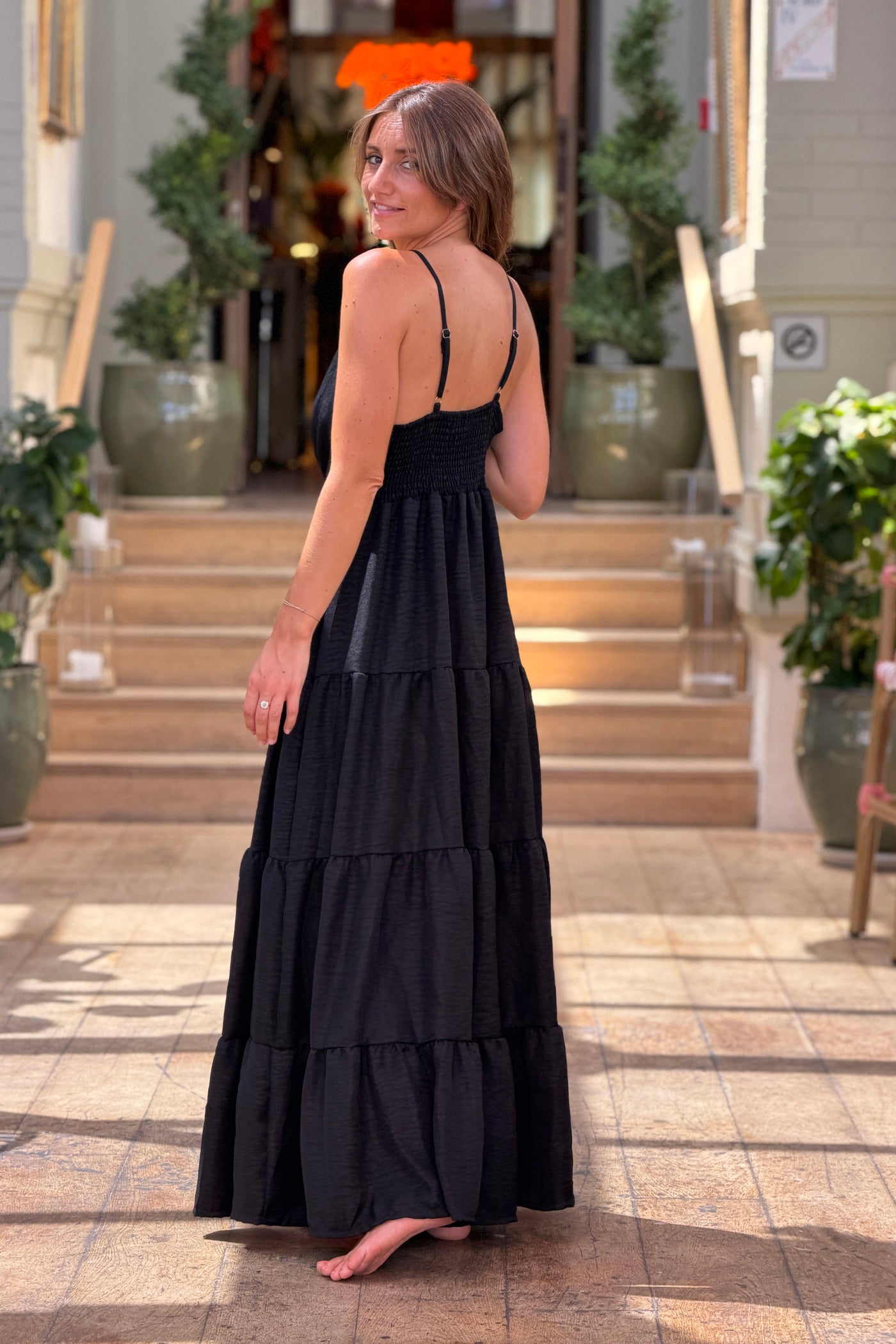 Robe longue à bretelles noire détail broche soleil doré