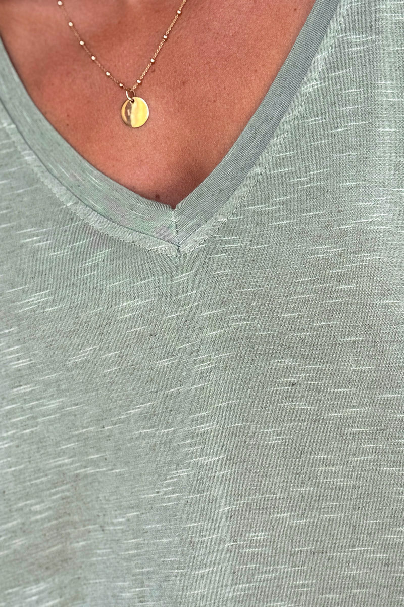 Camiseta holgada, elástica y de color caqui jaspeado, con cuello en V y mangas tipo murciélago.